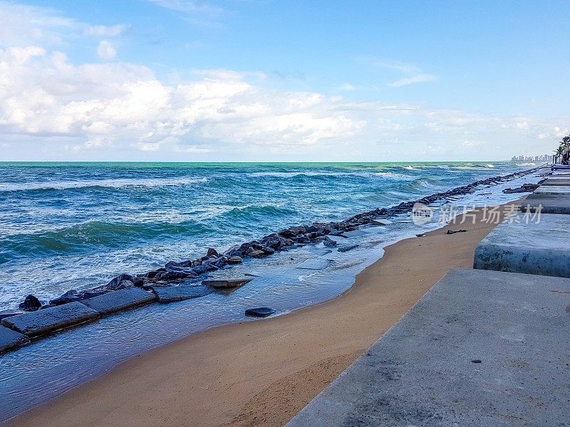 在巴西累西腓的Boa Viagem海滩，强大的蓝色海浪正向海浪块前进